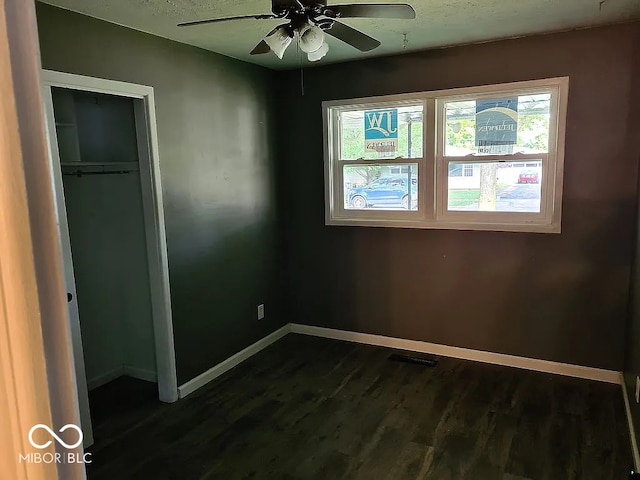 unfurnished bedroom featuring dark hardwood / wood-style flooring, a closet, and ceiling fan