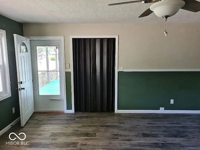 foyer entrance featuring a textured ceiling, ceiling fan, and dark hardwood / wood-style flooring