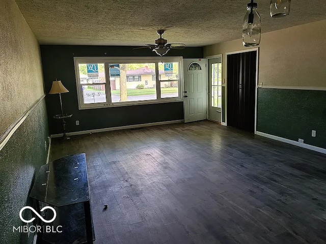 unfurnished room featuring a textured ceiling, dark hardwood / wood-style floors, and ceiling fan