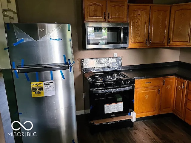 kitchen with stainless steel appliances and dark hardwood / wood-style flooring