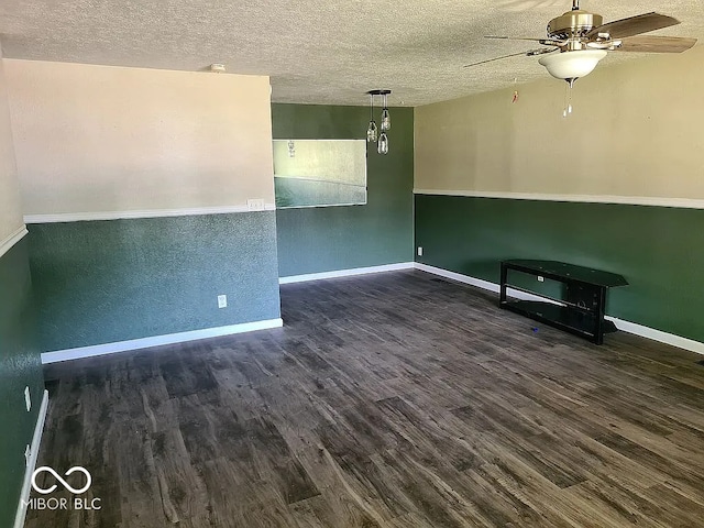 empty room with a textured ceiling, ceiling fan, and dark hardwood / wood-style flooring