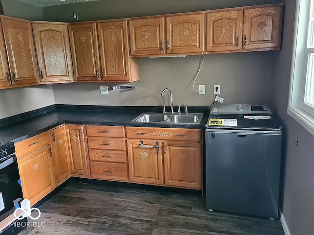 kitchen with washer / dryer, sink, dark hardwood / wood-style floors, and stainless steel range with electric cooktop