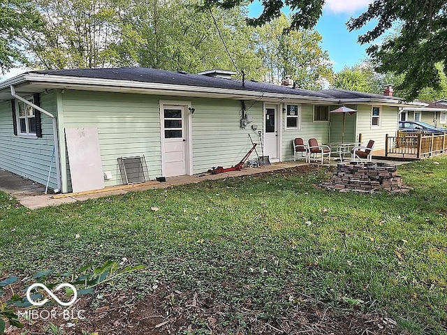 back of house with a patio area, a lawn, and a fire pit