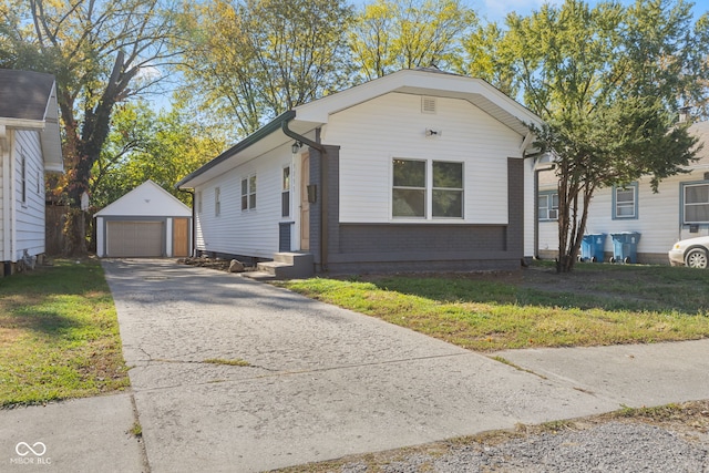 view of front facade with a front yard, an outbuilding, and a garage