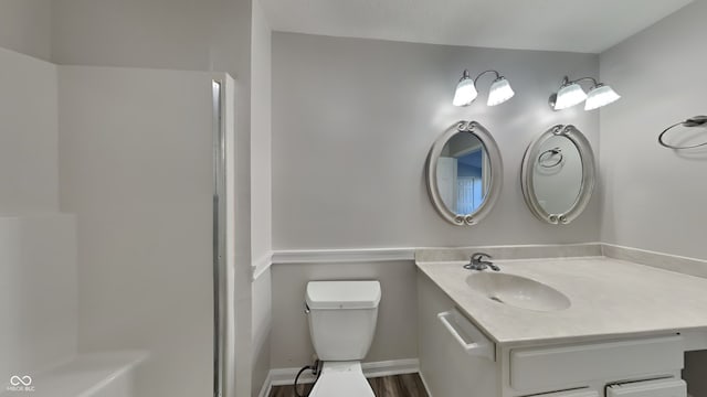 bathroom with toilet, vanity, and wood-type flooring