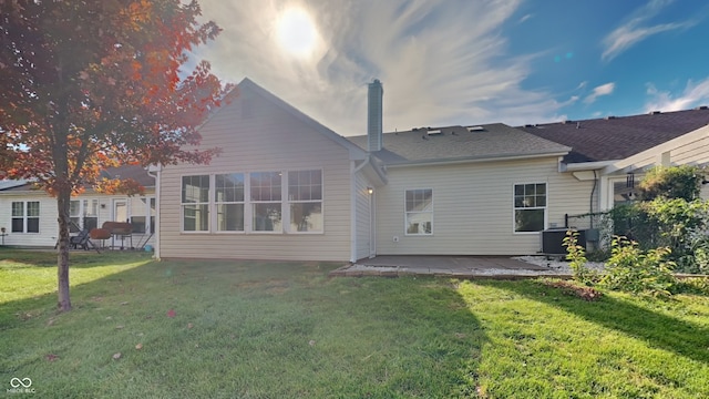 rear view of house featuring central AC, a yard, and a patio