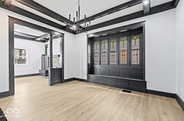 empty room featuring a chandelier and light wood-type flooring