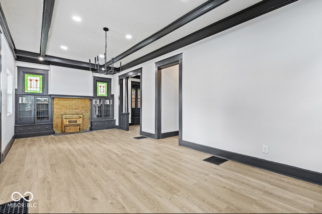 unfurnished living room with beam ceiling, a chandelier, and light hardwood / wood-style floors