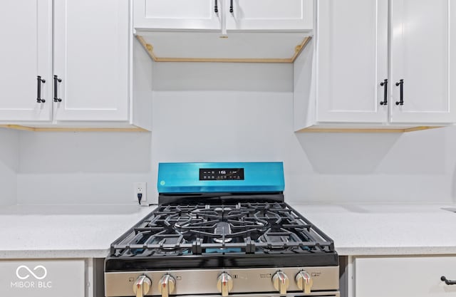 kitchen featuring white cabinetry, light stone countertops, and stainless steel gas stove