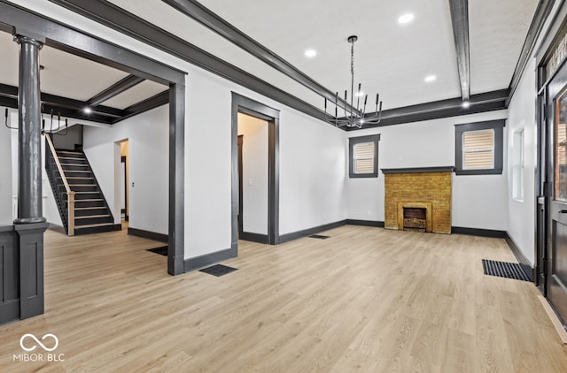 unfurnished living room featuring beam ceiling and light wood-type flooring