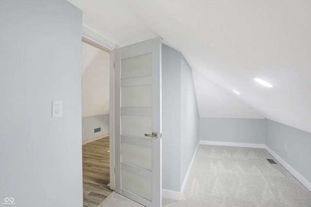 bonus room featuring vaulted ceiling and light carpet