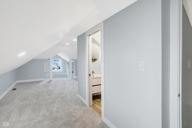 bonus room with light carpet and vaulted ceiling