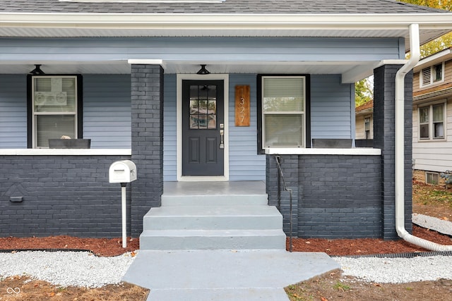 view of exterior entry with a porch