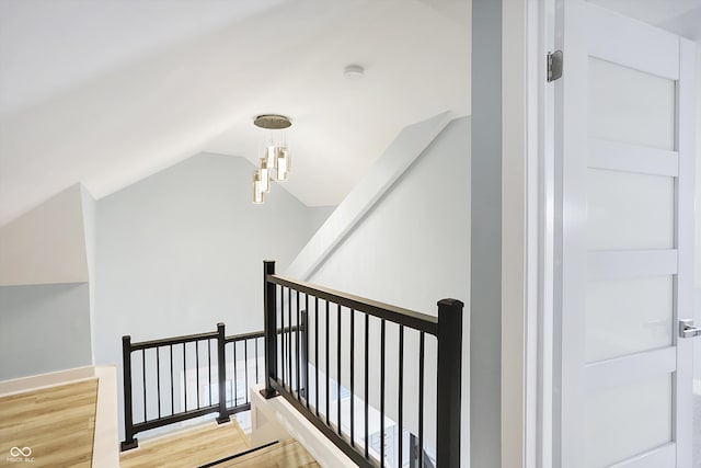 staircase with vaulted ceiling and wood-type flooring