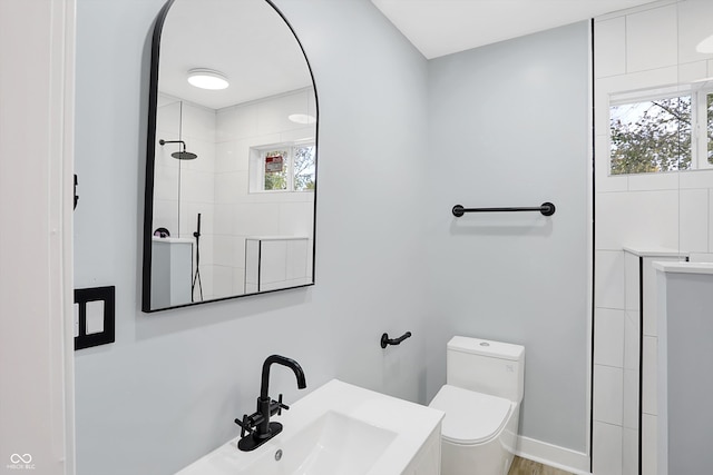 bathroom featuring sink, toilet, and tiled shower