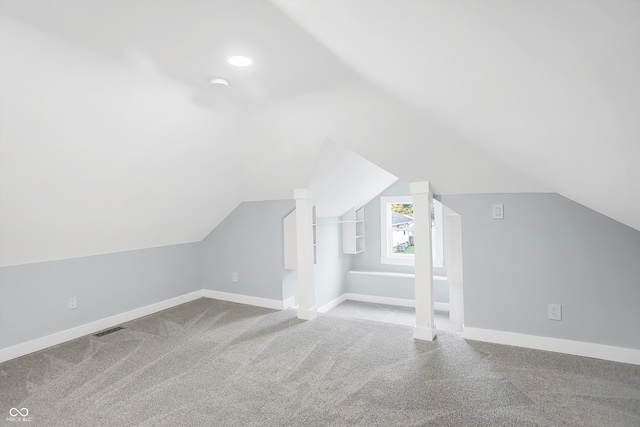 bonus room with light colored carpet and lofted ceiling