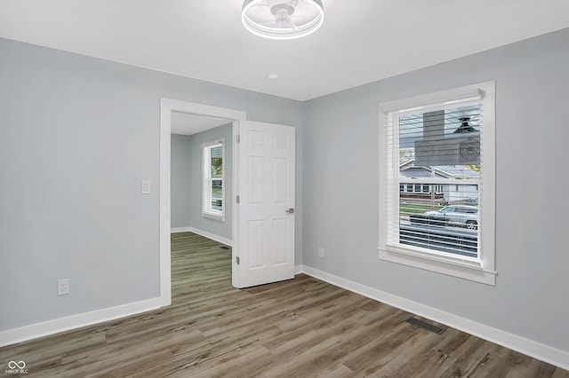 empty room with plenty of natural light and wood-type flooring