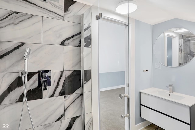 bathroom with a shower with shower door and vanity