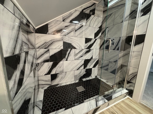 interior details with a tile shower and wood-type flooring