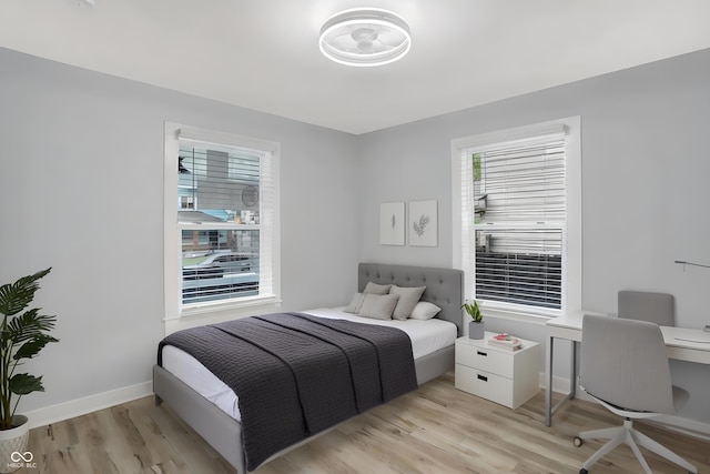 bedroom featuring multiple windows and light wood-type flooring