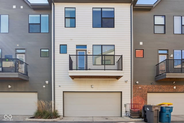 rear view of house with a garage and a balcony