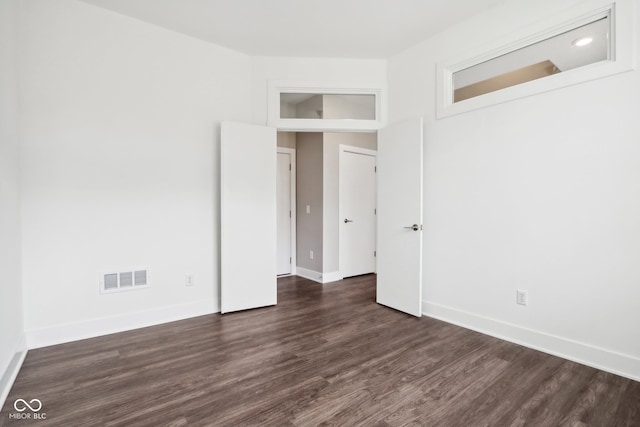 empty room with dark hardwood / wood-style flooring