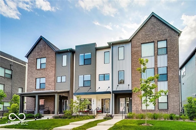 townhome / multi-family property featuring a porch and a front lawn