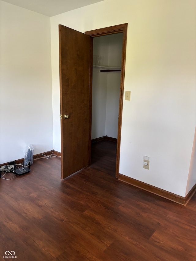 unfurnished room with dark wood-type flooring