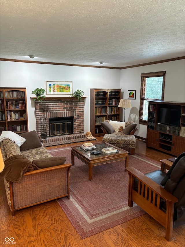 living room featuring hardwood / wood-style flooring, a textured ceiling, and ornamental molding