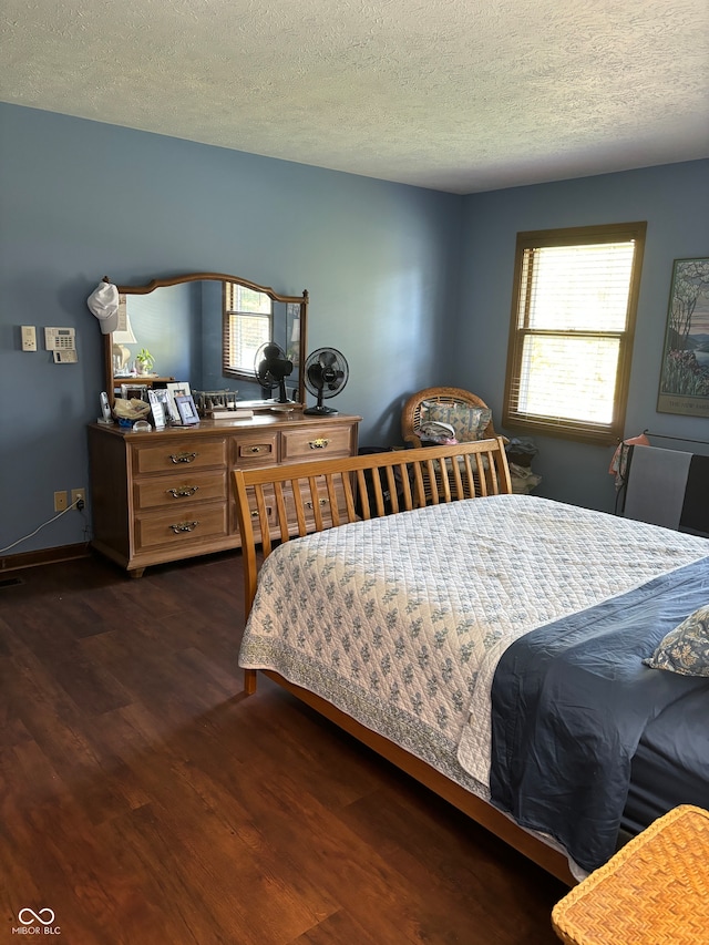 bedroom featuring a textured ceiling and dark hardwood / wood-style flooring