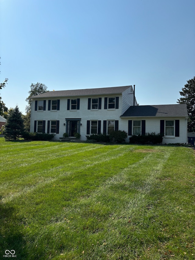 colonial home featuring a front lawn