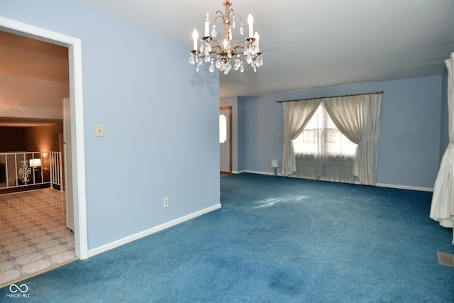 carpeted spare room featuring a chandelier