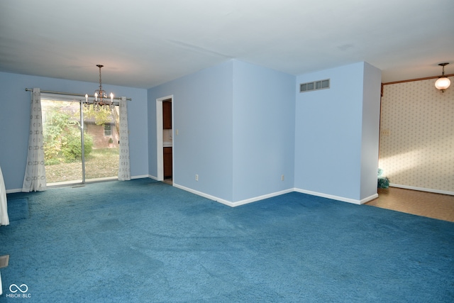 carpeted spare room with an inviting chandelier