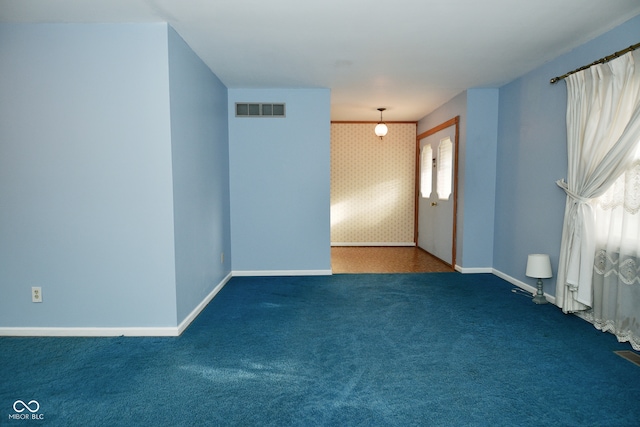 unfurnished room featuring a wealth of natural light and carpet floors