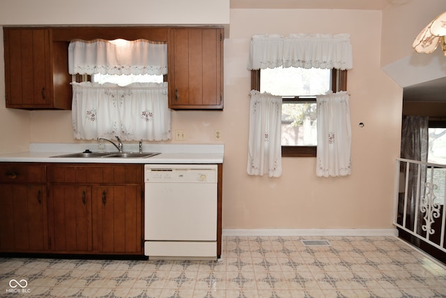 kitchen featuring a healthy amount of sunlight, sink, and white dishwasher