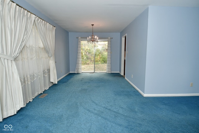 carpeted empty room featuring a chandelier