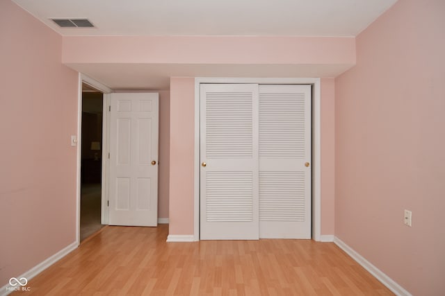 unfurnished bedroom with light hardwood / wood-style flooring and a closet