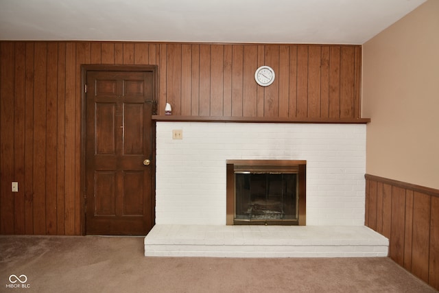 room details with a fireplace, wood walls, and carpet