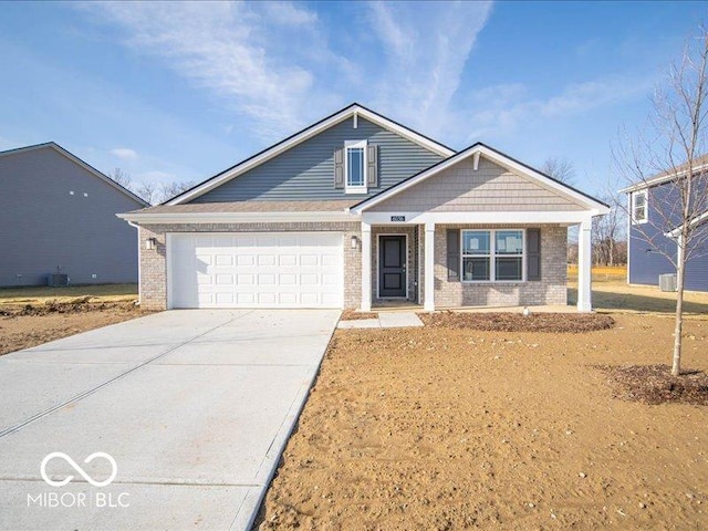 craftsman-style house with brick siding, an attached garage, driveway, and a porch