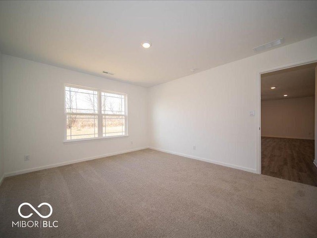 spare room featuring dark colored carpet