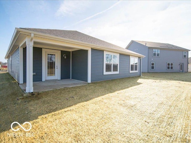 rear view of property featuring a patio area and a yard