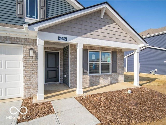 doorway to property featuring a garage and covered porch