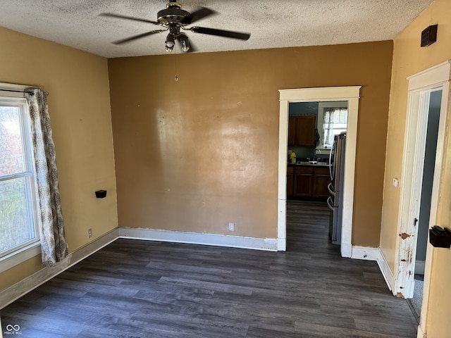 spare room featuring a textured ceiling, ceiling fan, sink, and dark hardwood / wood-style flooring