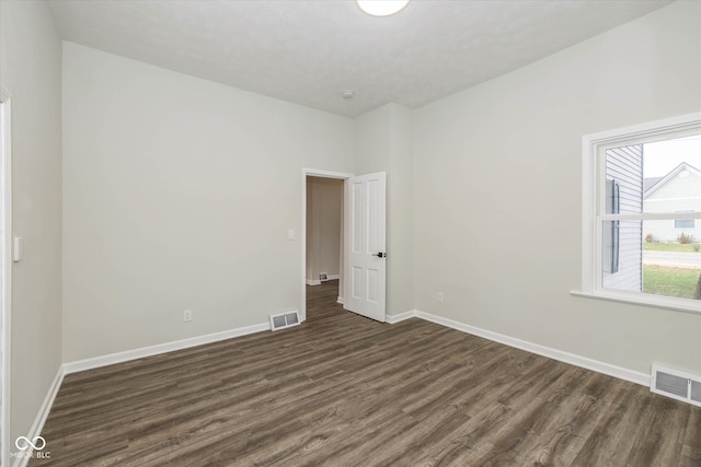 spare room featuring dark wood-type flooring