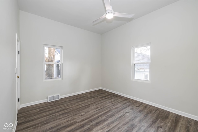 spare room with dark hardwood / wood-style flooring, ceiling fan, and a healthy amount of sunlight