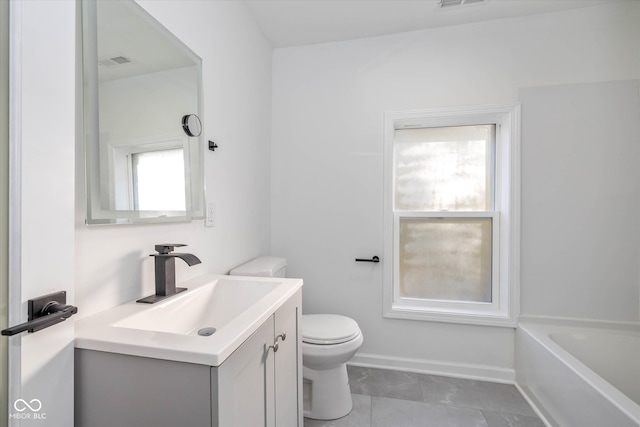 bathroom featuring a tub, vanity, a healthy amount of sunlight, and toilet