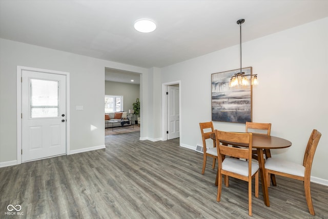 dining space featuring dark hardwood / wood-style flooring and a notable chandelier