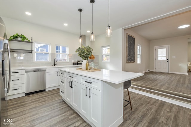 kitchen featuring dishwasher, hardwood / wood-style flooring, and plenty of natural light