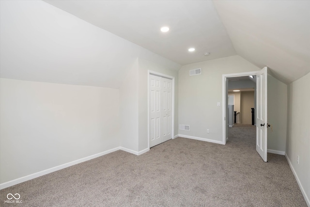 additional living space featuring light carpet and lofted ceiling