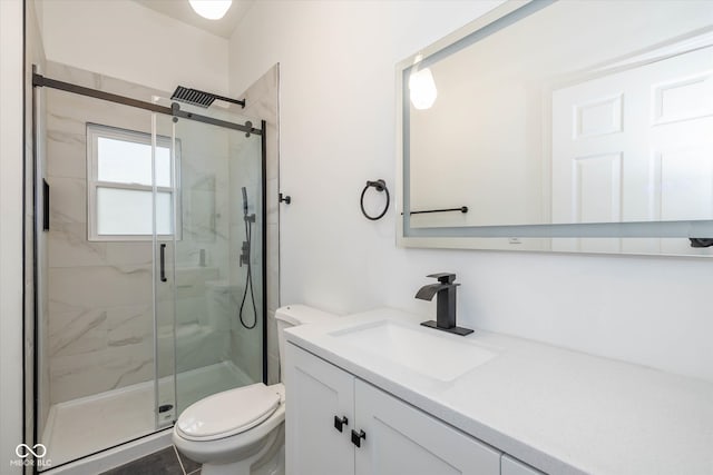 bathroom featuring vanity, toilet, and a shower with door